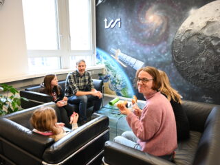 A school class visiting ISSI and discussing space science next to the ISSI Mural. (Picture by A. Fischer)