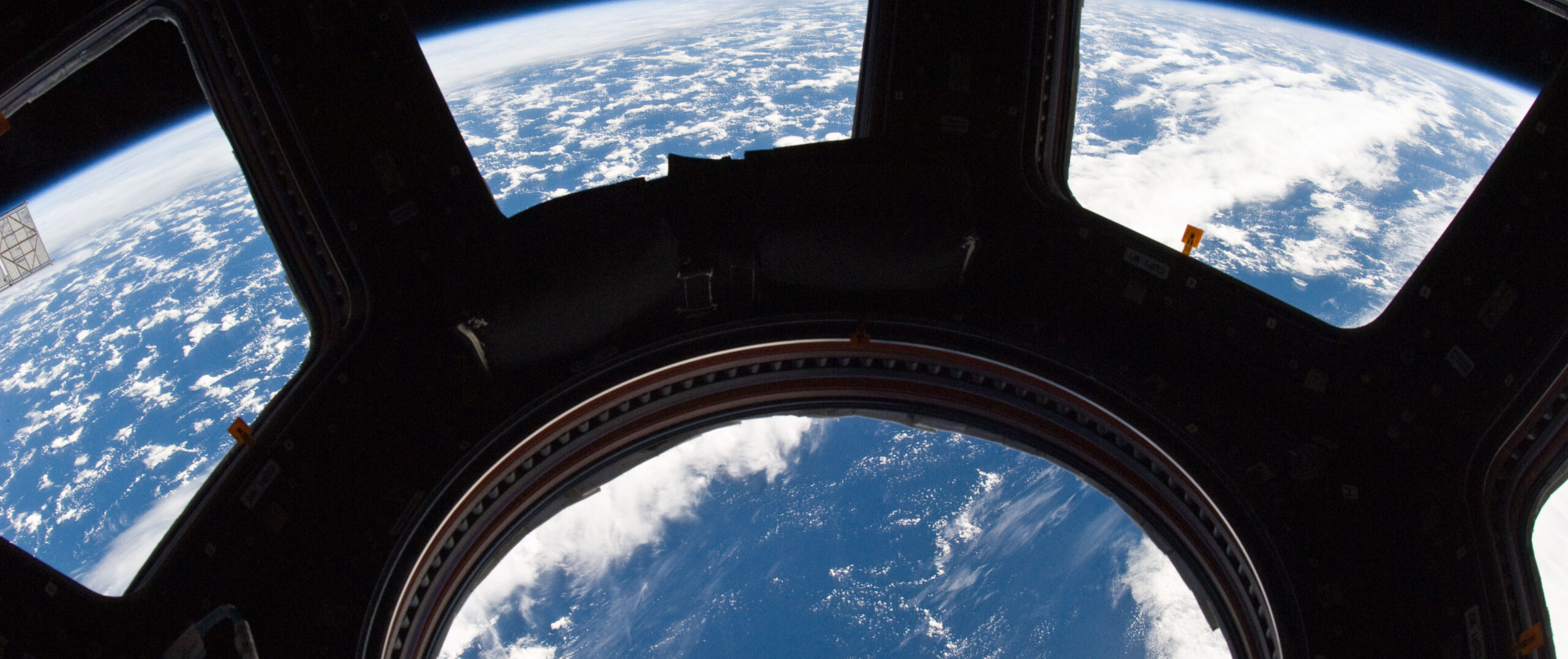 A blue and white part of Earth and its horizon, as seen through the windows in the Cupola, are featured in this image photographed by an Expedition 22 crew member on the International Space Station. NASA photo ISS022-E-080014