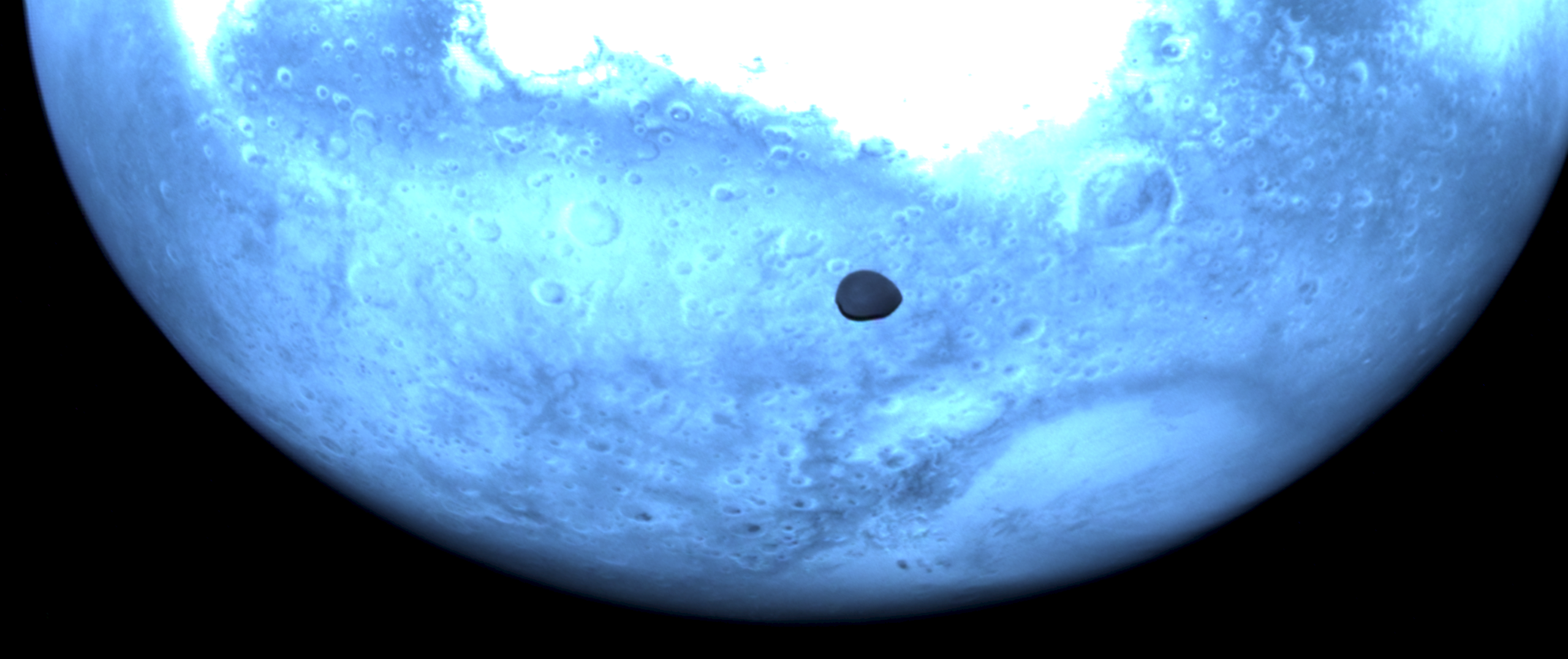 Mars and Deimos viewed by Hera's Hyperscout H. The red planet appears light blue in this near-infrared Hyperscout H image from ESA’s Hera spacecraft. credit: ESA